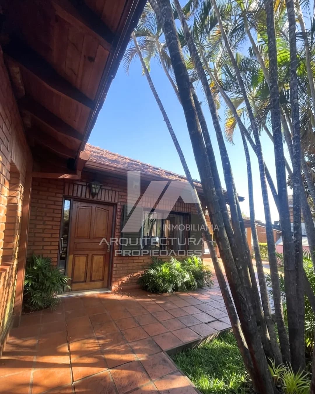Casa rústica de ladrillo con palmeras