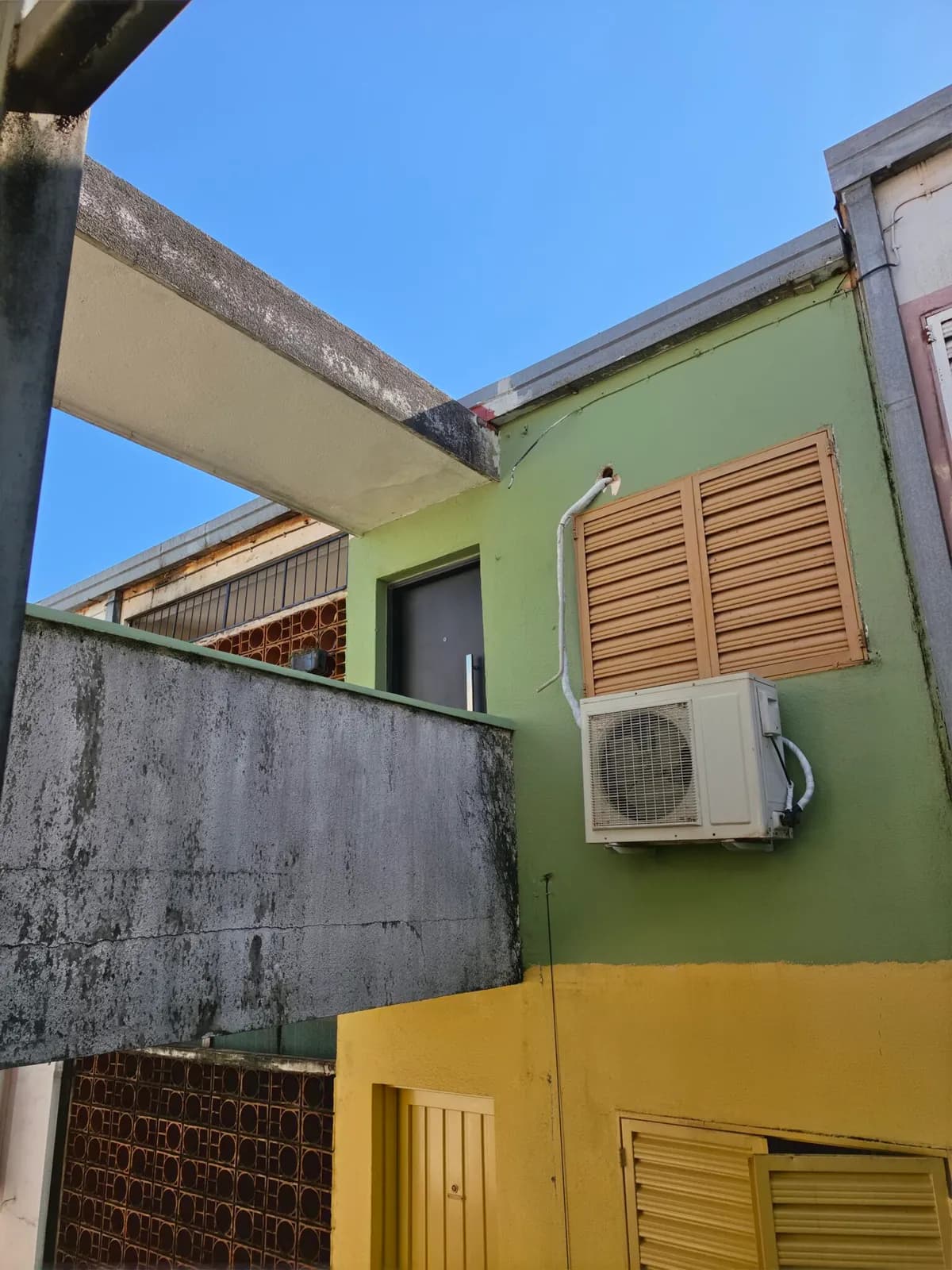 Fachada de casa verde y amarilla