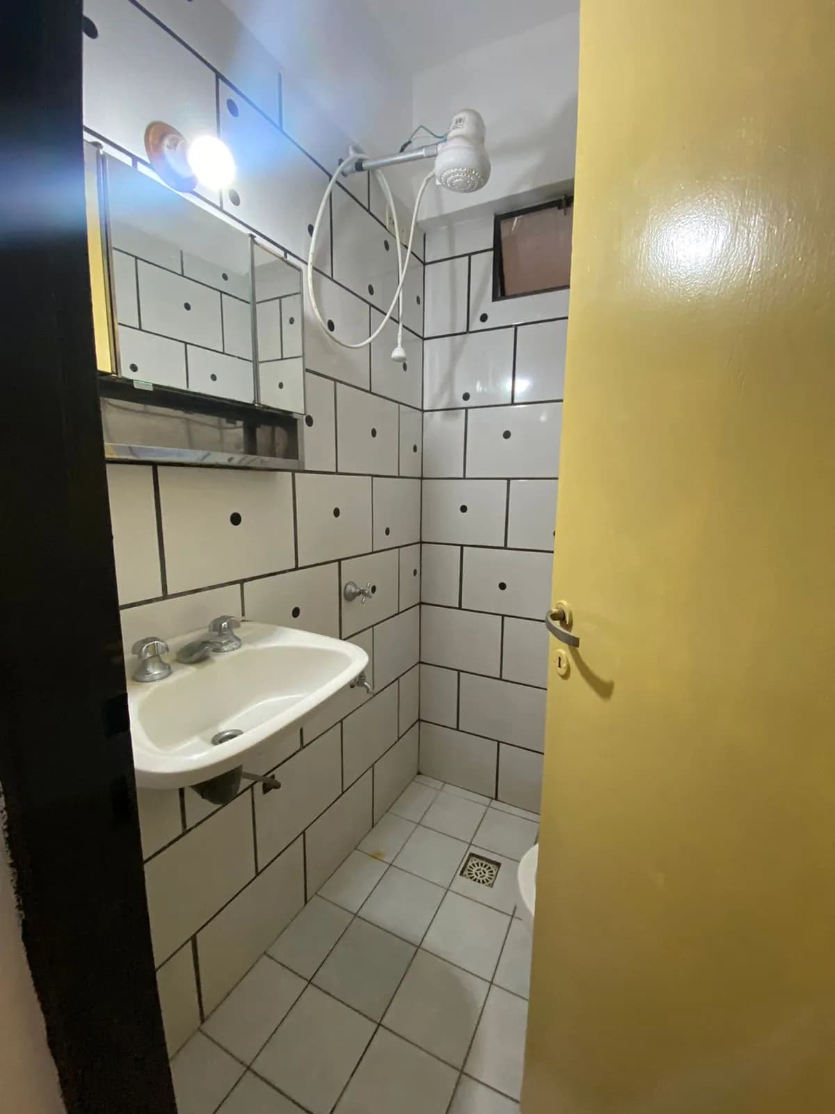 Baño compacto con azulejos blancos