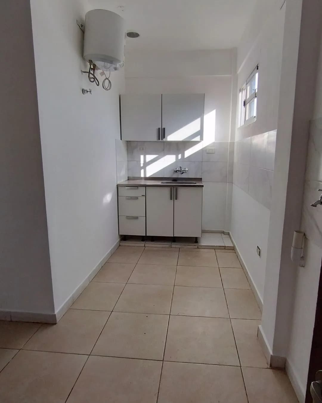 Cocina compacta con muebles blancos