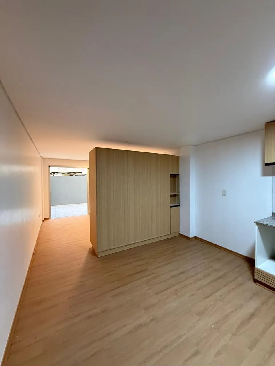 Monoambiente luminoso con divisor de madera