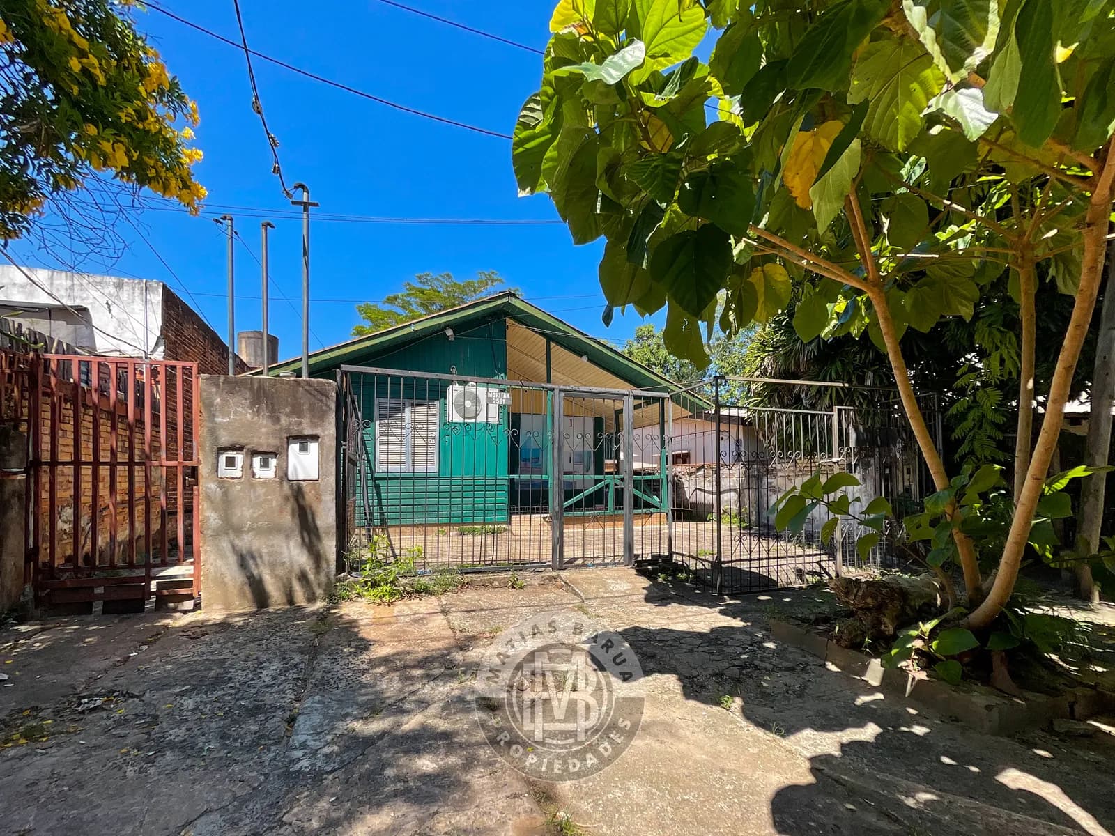 Casa verde con rejas al frente
