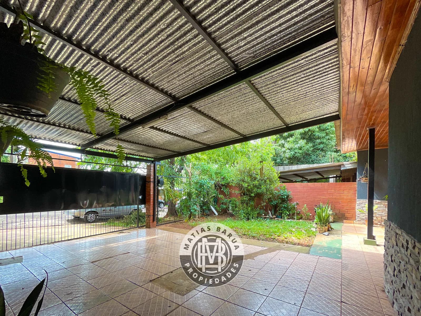 Amplia cochera techada con jardín