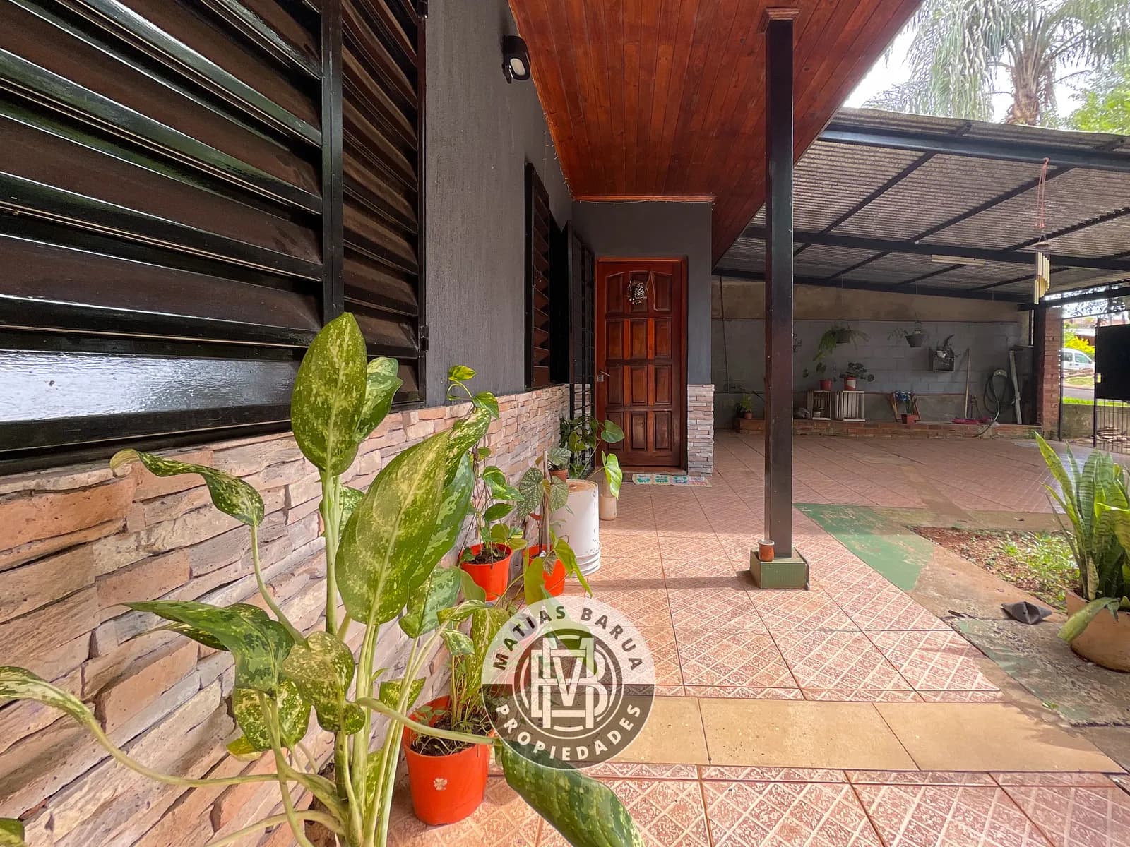 Galería techada con plantas en macetas