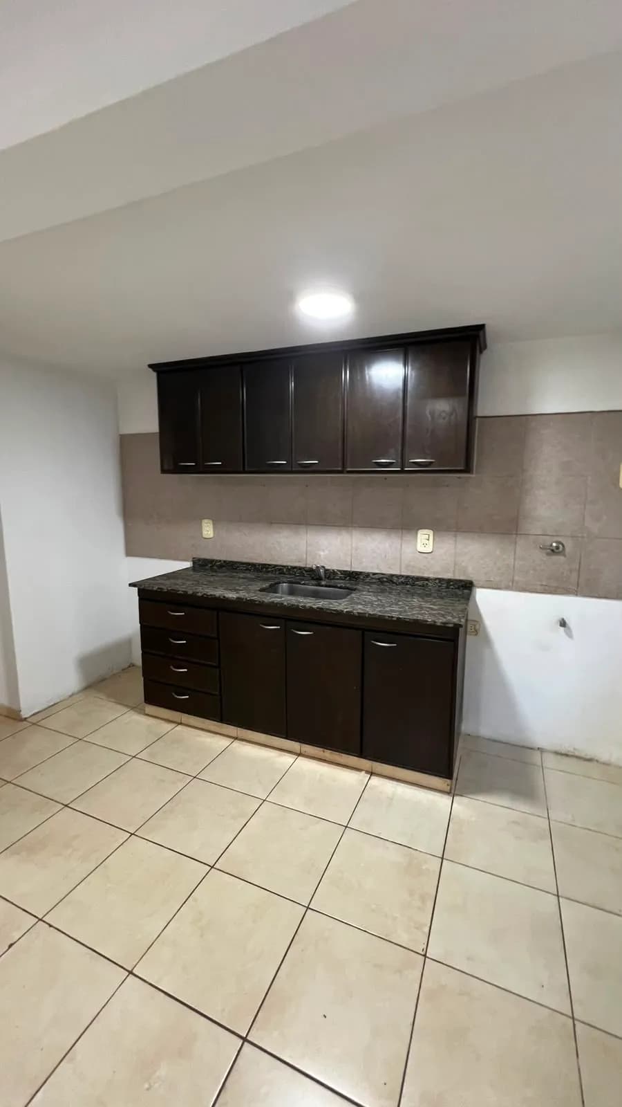 Cocina con gabinetes de madera oscura