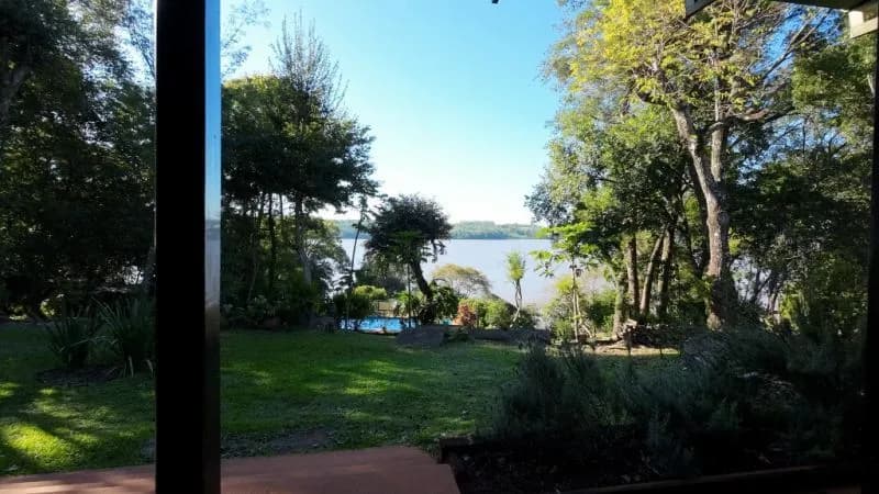 Jardín arbolado con vista al río
