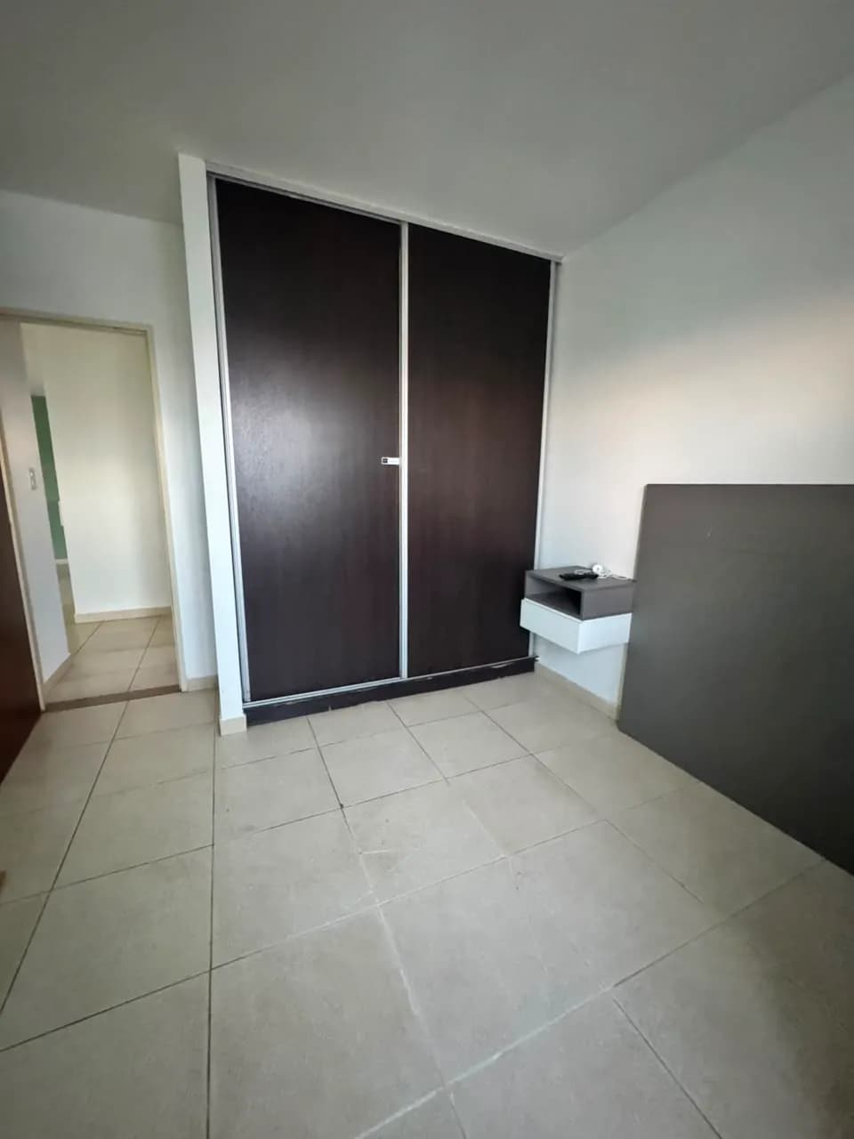 Dormitorio vacío con placard oscuro