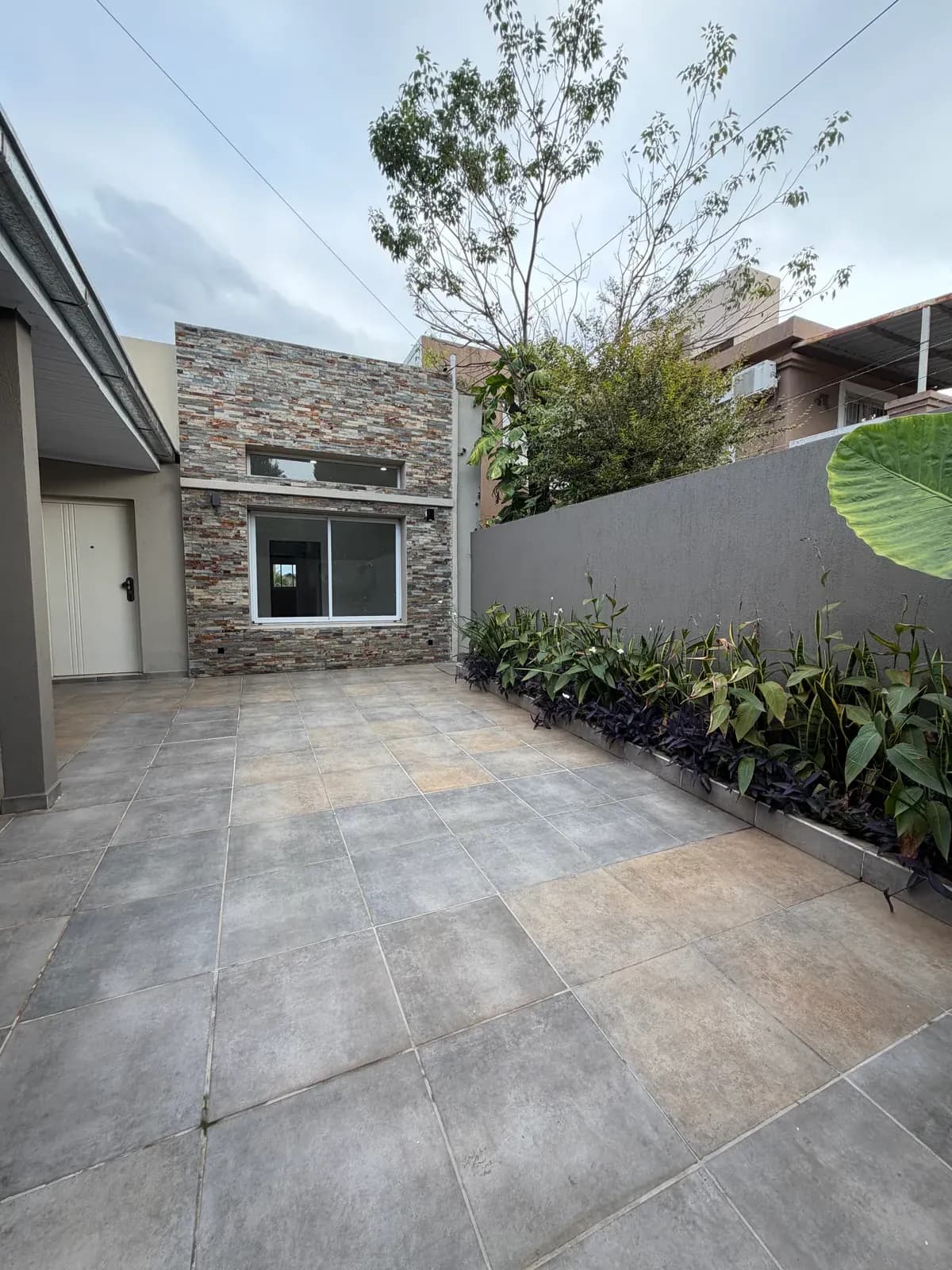 Patio moderno con fachada de piedra