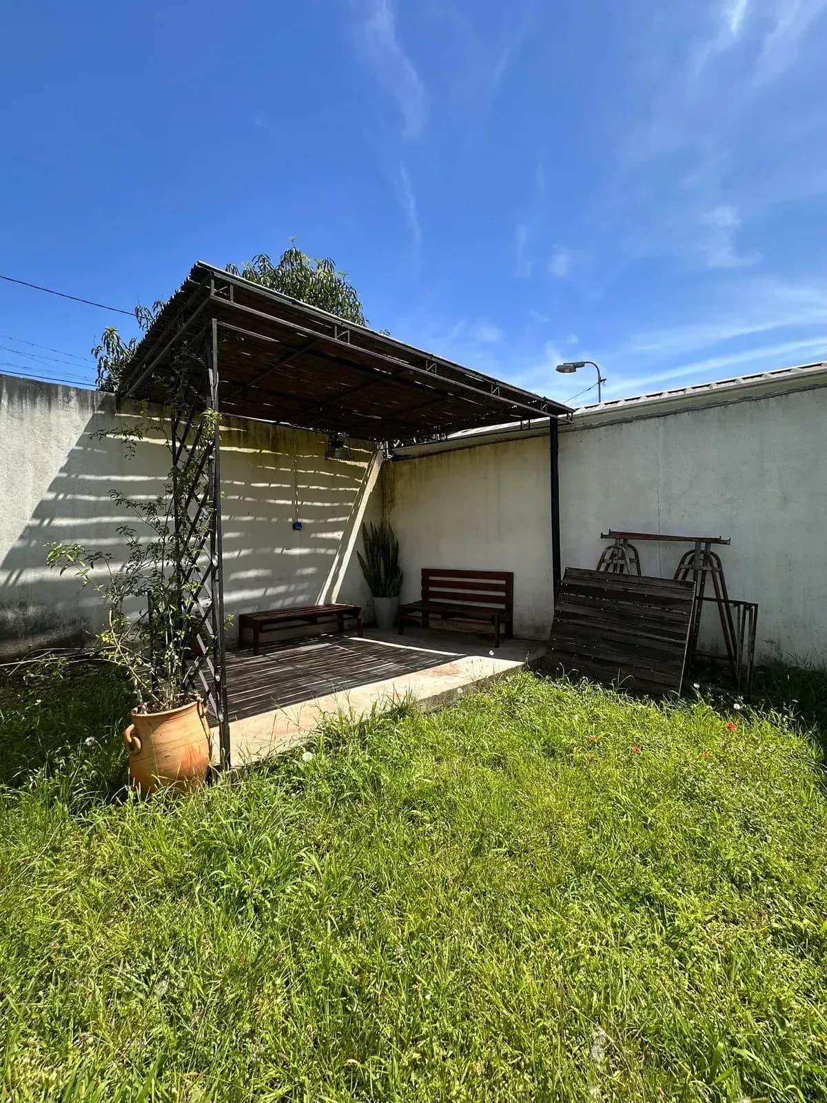 Jardín exterior con pérgola de madera