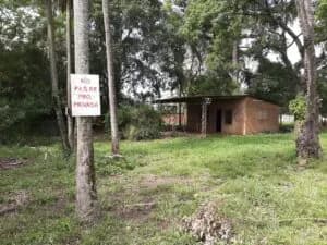 Terreno arbolado con pequeña construcción