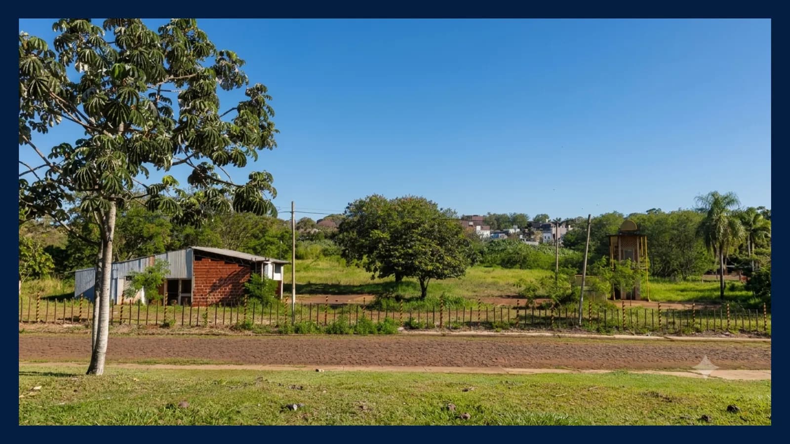 Amplio terreno con árboles y construcción