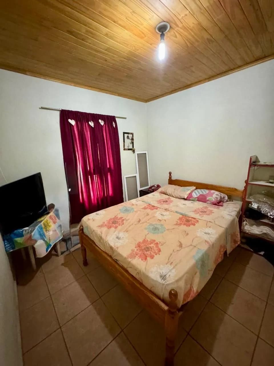 Dormitorio sencillo con techo de madera