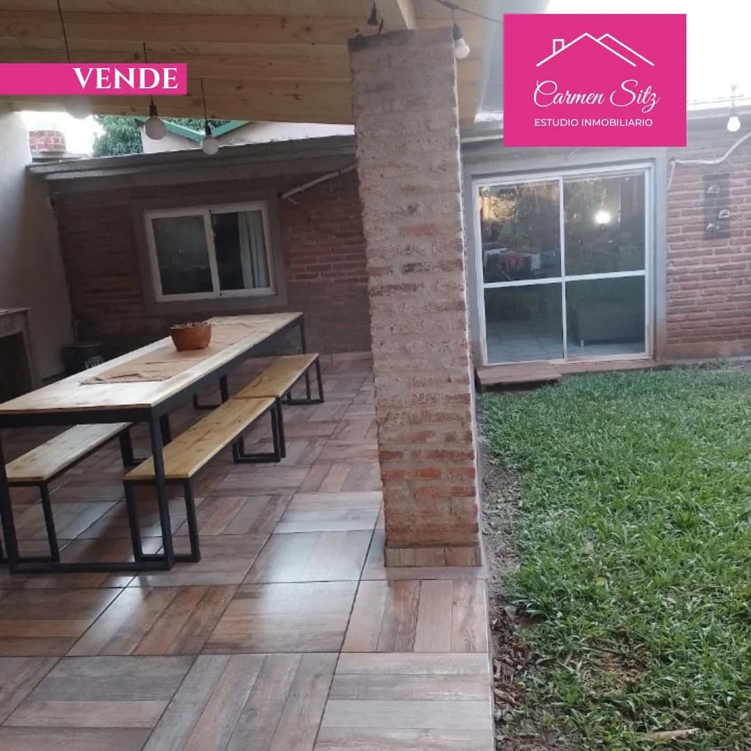 Galería cubierta con mesa y jardín
