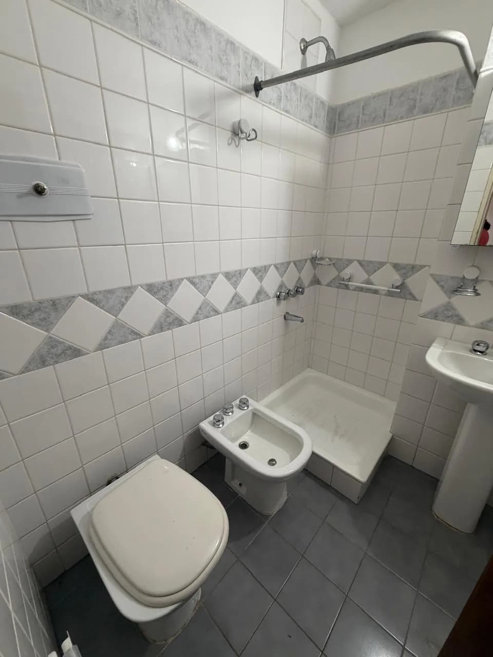 Baño completo con azulejos blancos