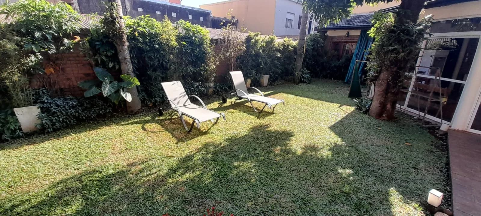 Amplio jardín verde con reposeras