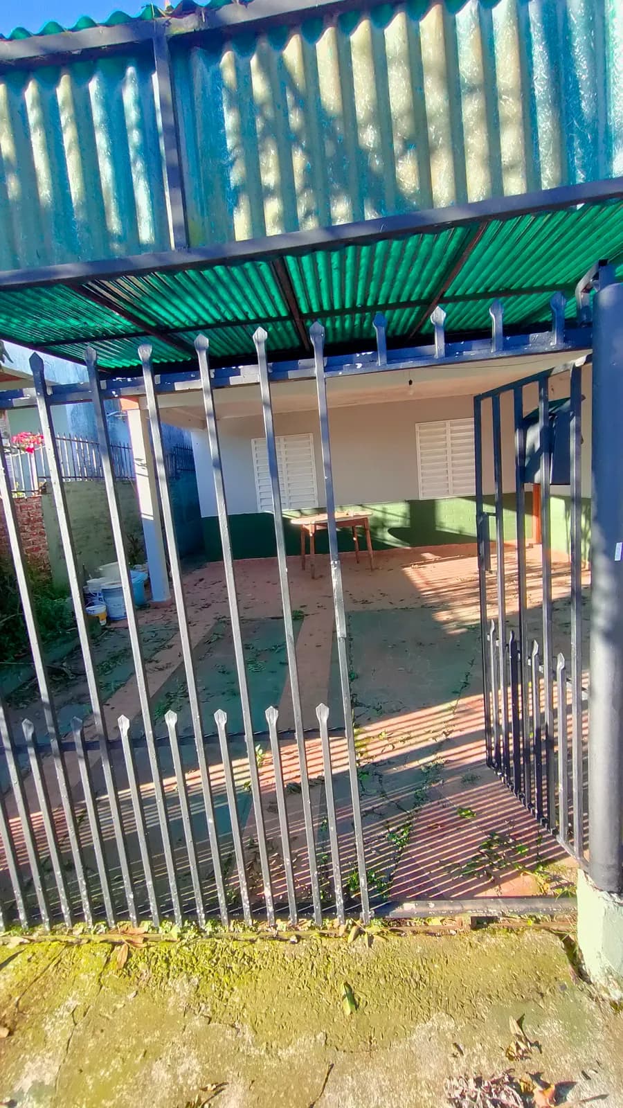 Entrada de casa con portón metálico
