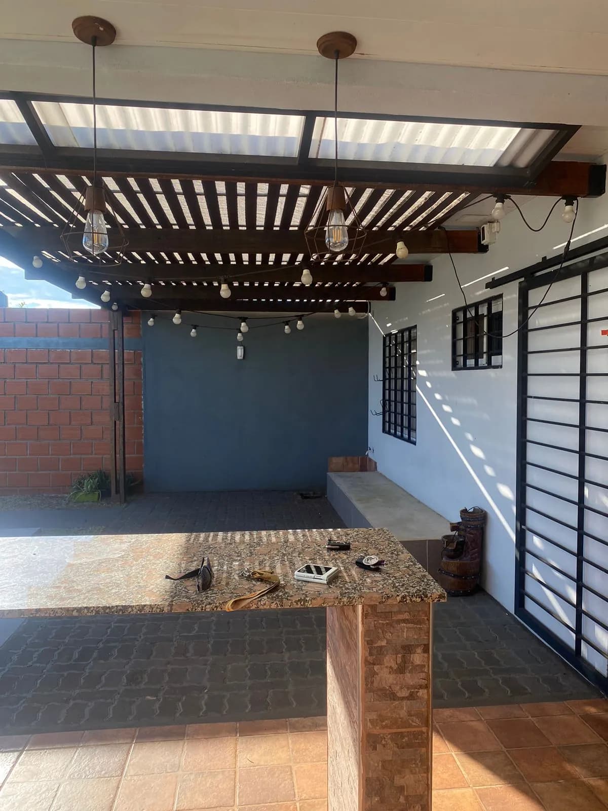 Patio techado con barra y pérgola