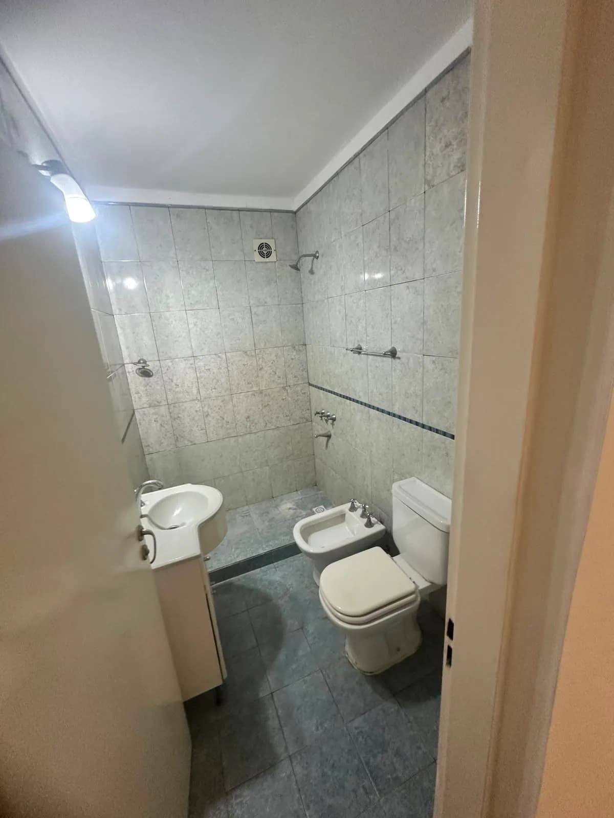 Baño completo con azulejos grises