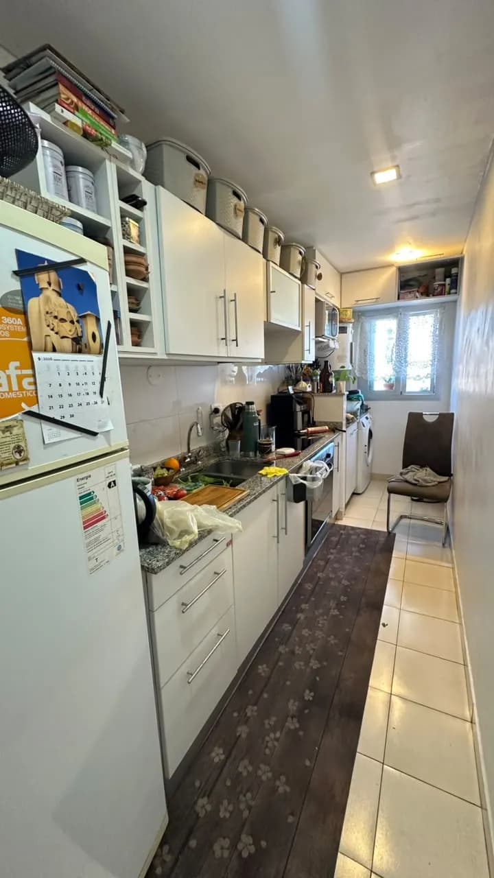 Cocina alargada con muebles blancos