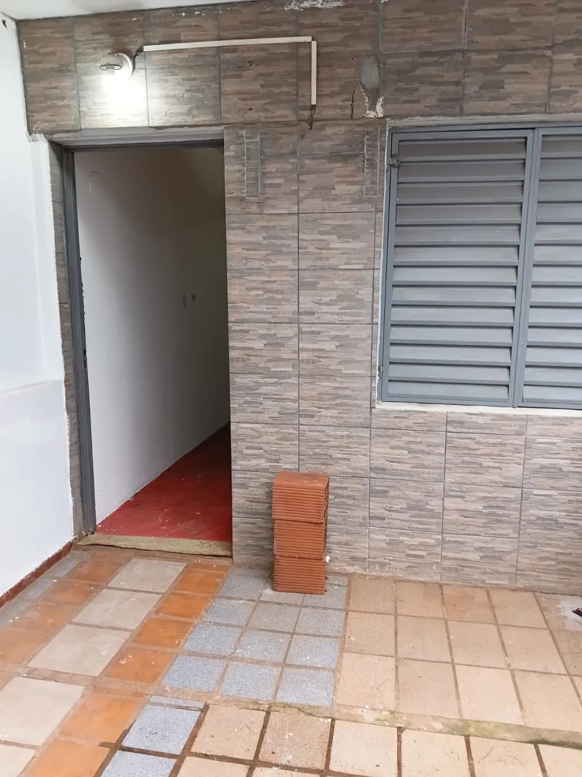 Entrada exterior con pared azulejada