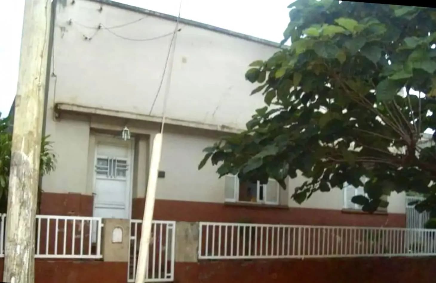 Fachada de casa con reja blanca