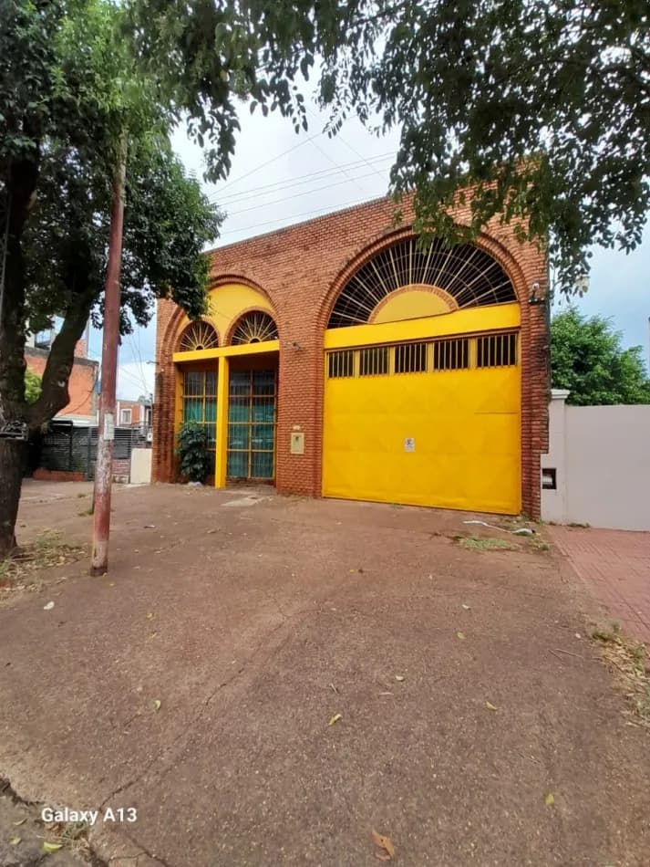 Fachada de ladrillo con portón amarillo