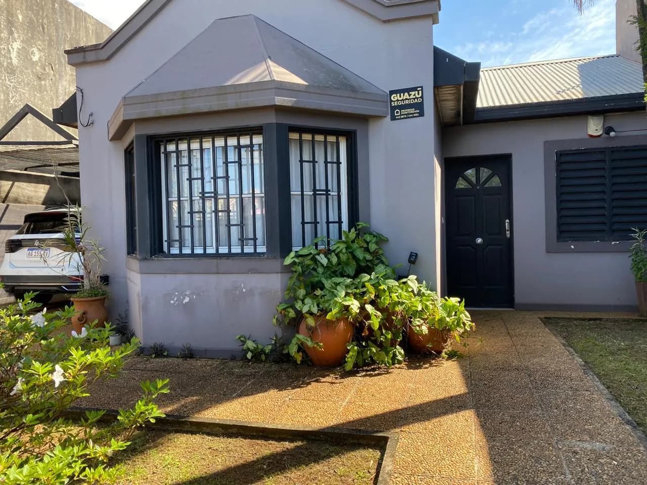 Casa moderna gris con jardín frontal