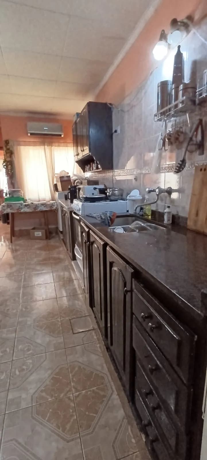 Cocina alargada con muebles oscuros