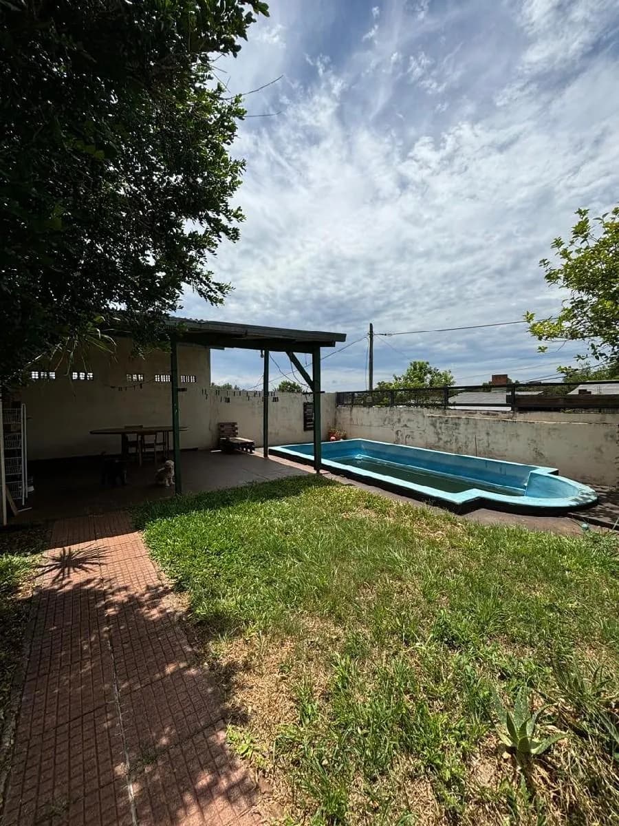 Jardín con piscina y galería techada