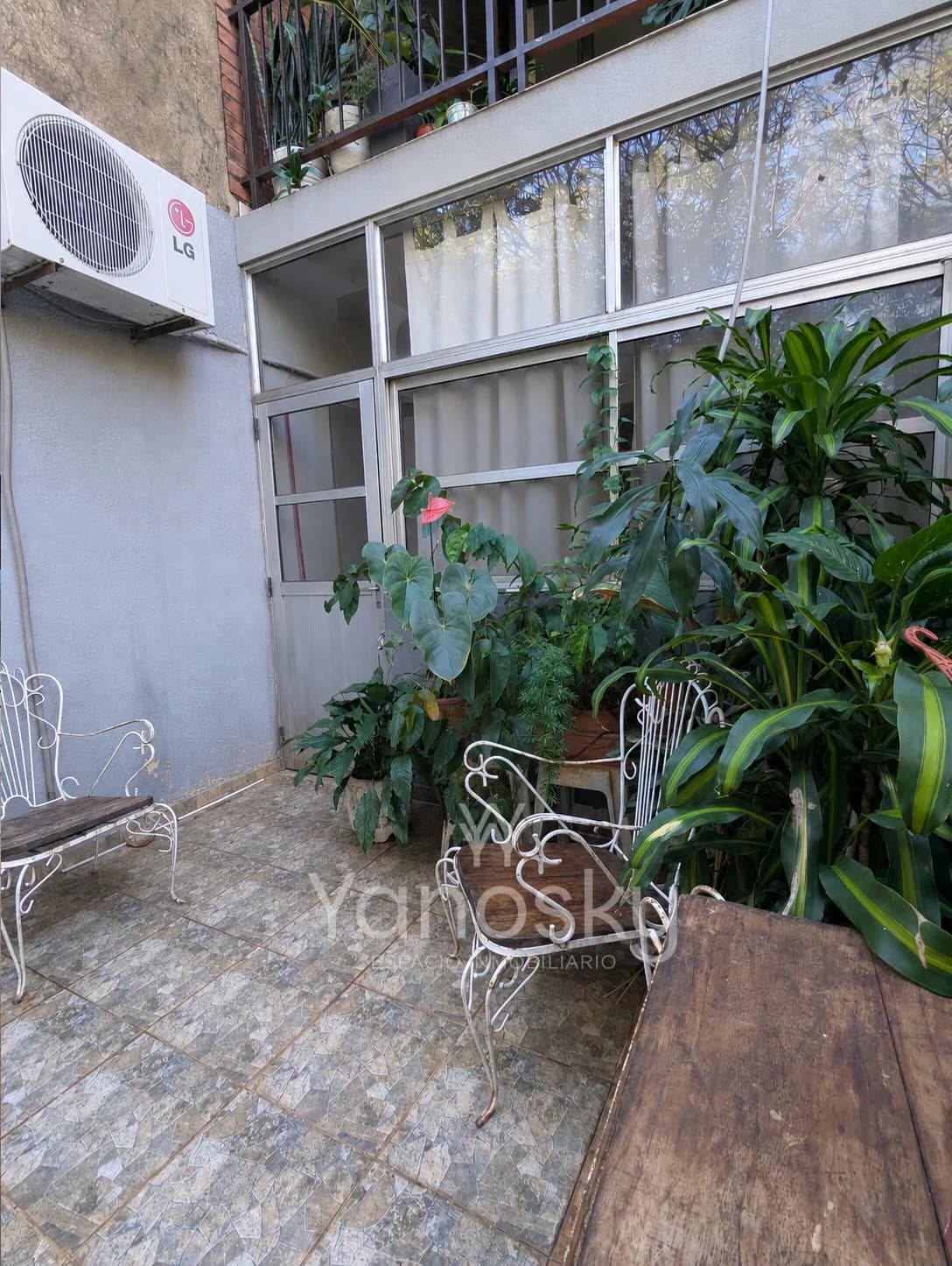 Patio interno con plantas y sillones